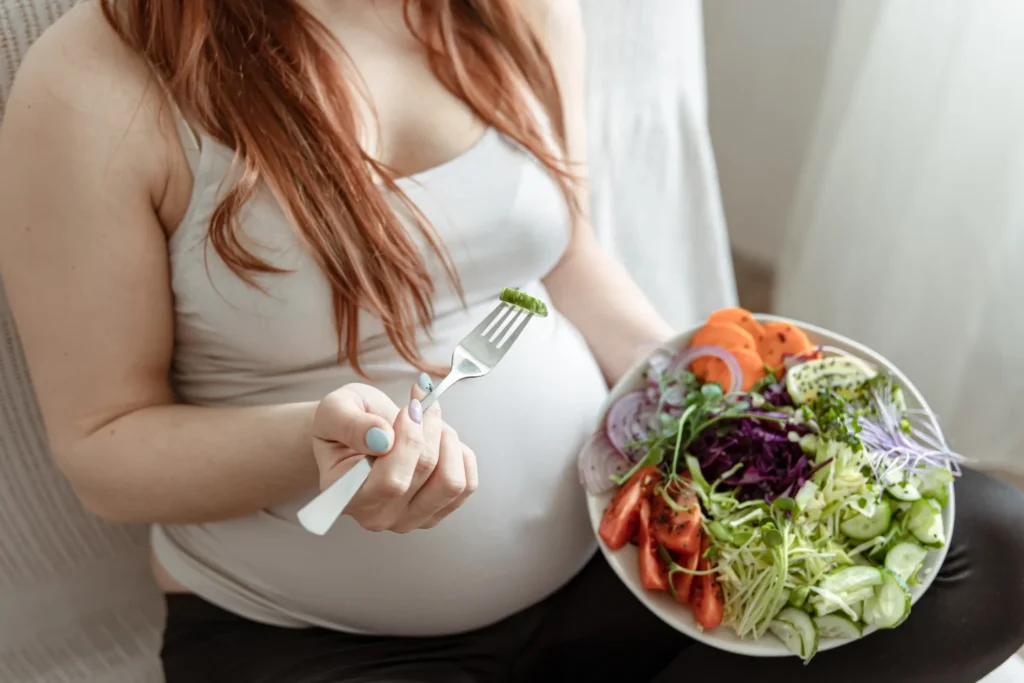 Mujer embarazada comiendo un plato de ensalada saludable durante su plan de nutrición online en Ekilib.