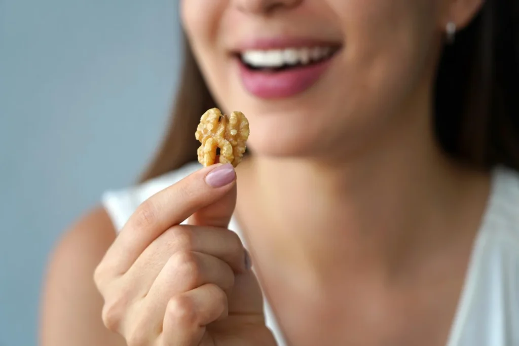 Persona sosteniendo una nuez, alimento rico en grasas saludables ideal para mejorar la sensibilidad a la insulina